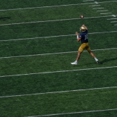 Notre Dame wide receiver in the act of trying to catch the ball.